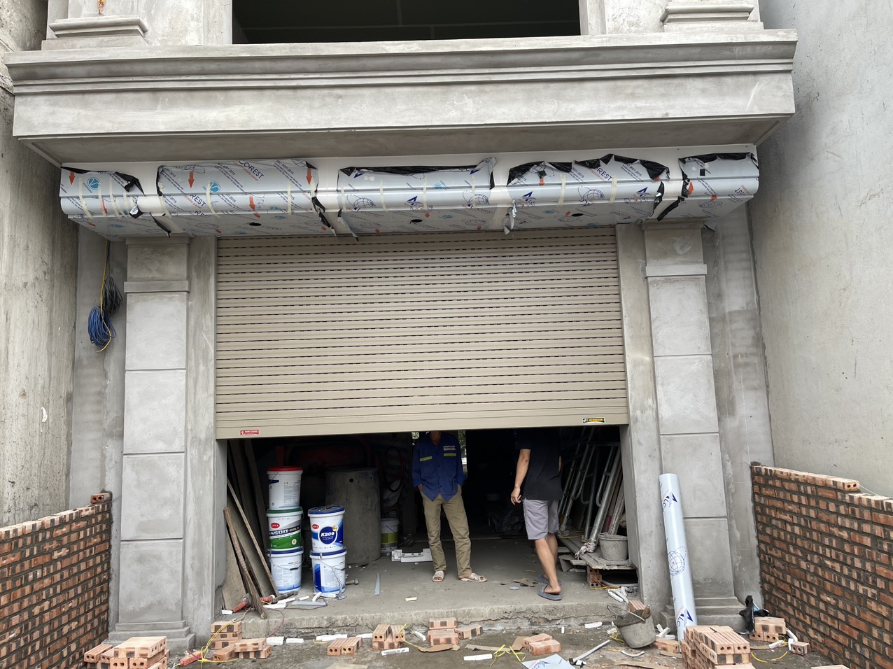 Nhân viên công ty Thành Đức kiểm tra tình trạng cửa cuốn cho khách hàng